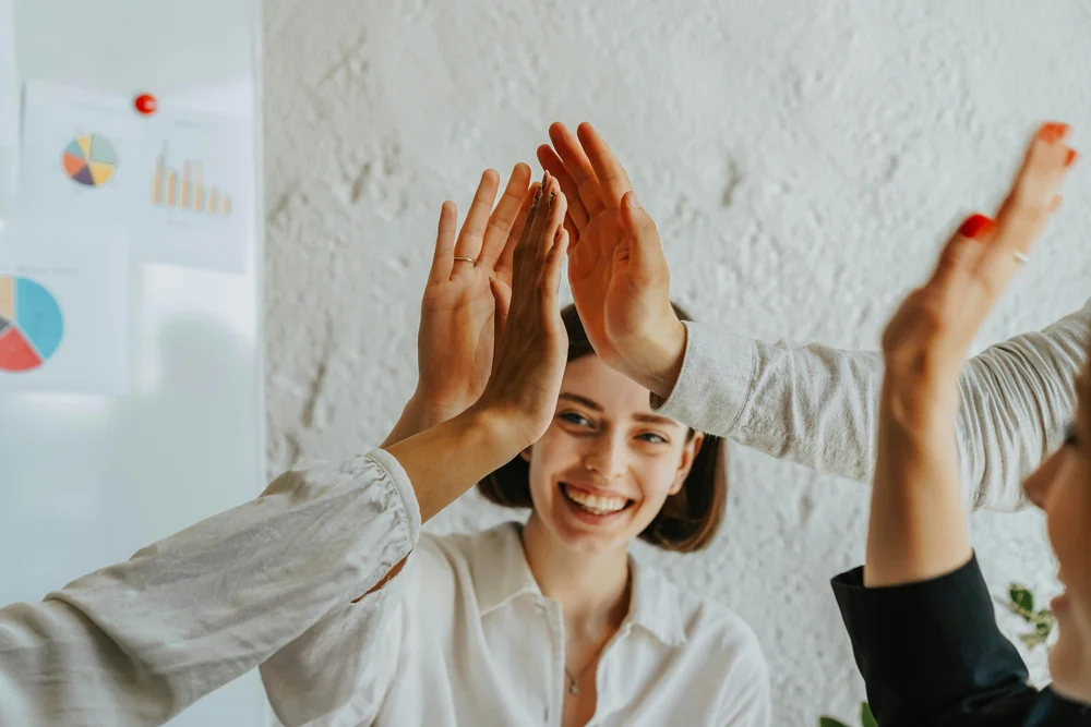 Support workers exchanging high fives during a training workshop.